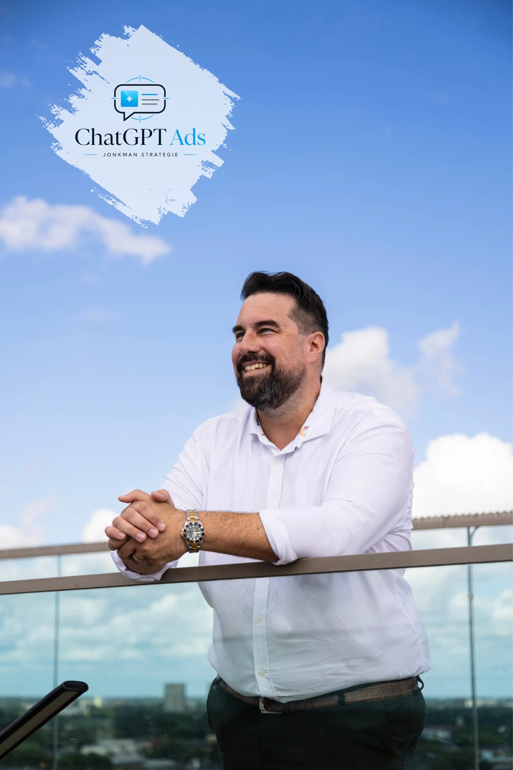 Man in wit overhemd leunt lachend op een glazen balustrade met blauwe lucht op de achtergrond en het logo van ChatGPT Ads Jonkman Strategie.